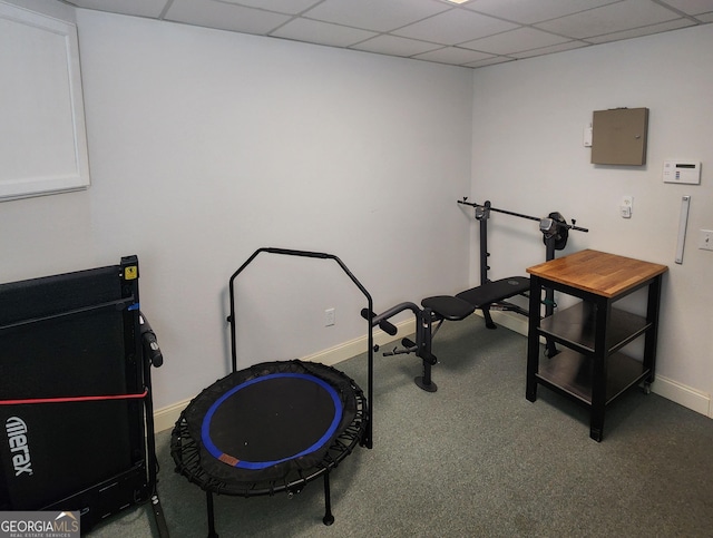 exercise area with baseboards, carpet, a drop ceiling, and electric panel
