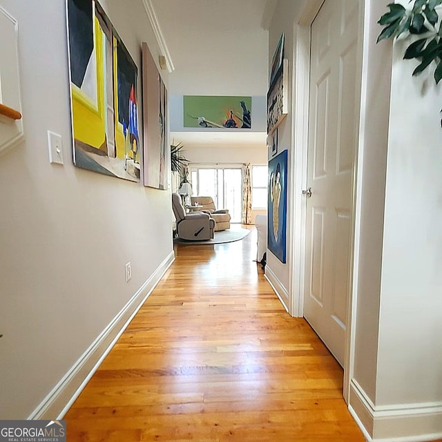 hallway featuring baseboards and light wood-type flooring