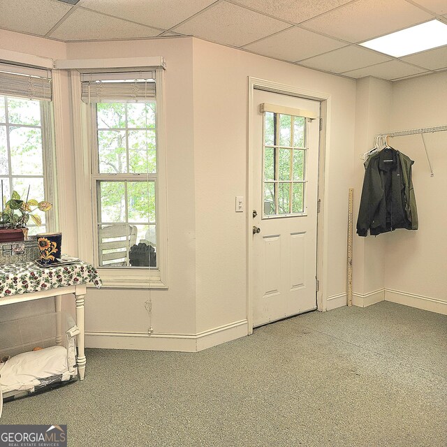 entryway with baseboards, a wealth of natural light, a paneled ceiling, and carpet