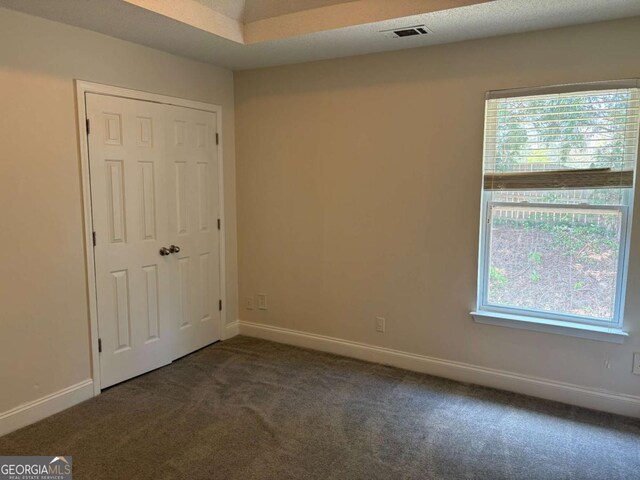 4234 Winston Cir, Atlanta, GA 30349 - unfurnished bedroom with baseboards, dark colored carpet, visible vents, and multiple windows