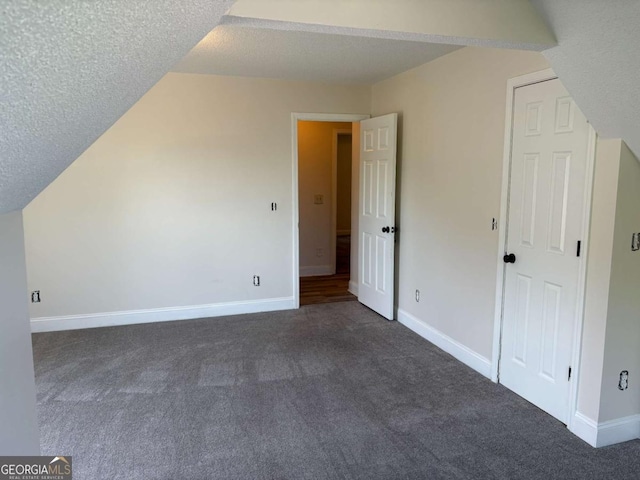 4234 Winston Cir, Atlanta, GA 30349 - additional living space featuring dark colored carpet, a textured ceiling, and baseboards