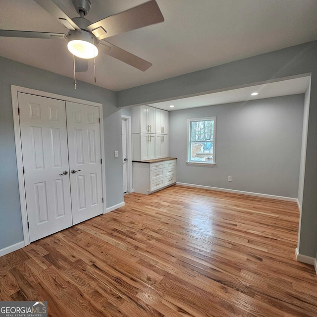 unfurnished bedroom with recessed lighting, light wood-style floors, a closet, and baseboards