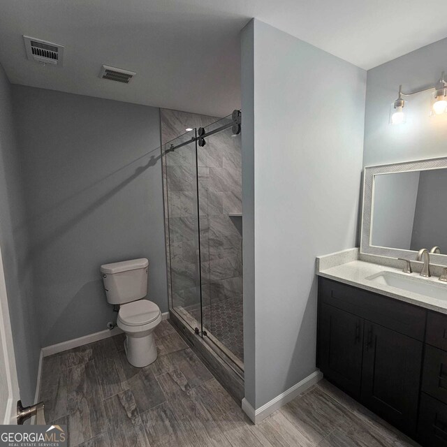 full bathroom with vanity, visible vents, a shower stall, and toilet
