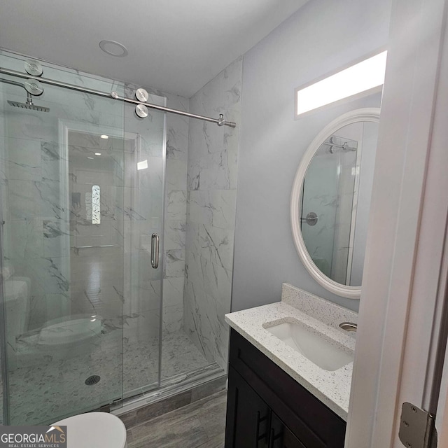 full bathroom with a marble finish shower and vanity