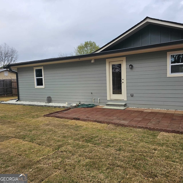 back of property with fence, a patio area, and a yard