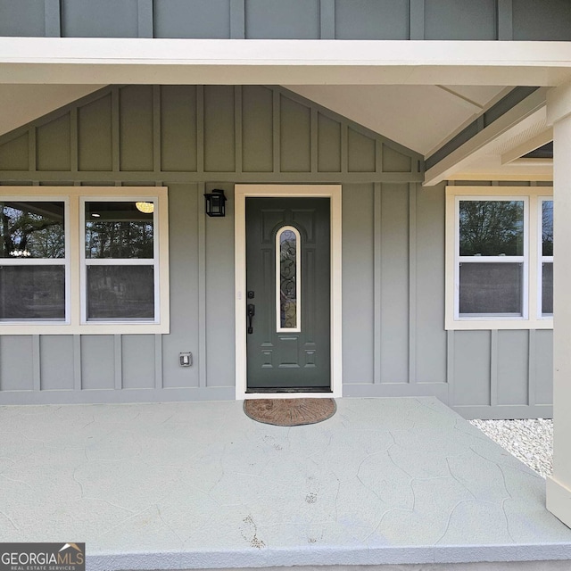 view of exterior entry featuring board and batten siding and a porch