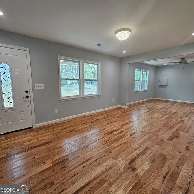 foyer featuring wood finished floors, visible vents, a ceiling fan, and baseboards
