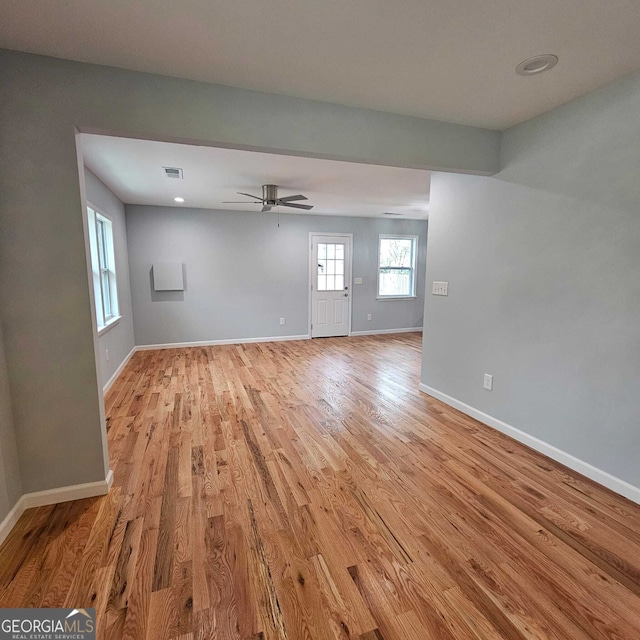 interior space with baseboards, visible vents, light wood-style floors, and ceiling fan
