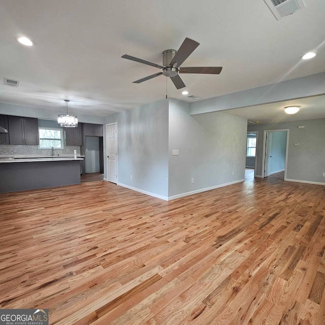 unfurnished living room with light wood-type flooring, baseboards, visible vents, and recessed lighting