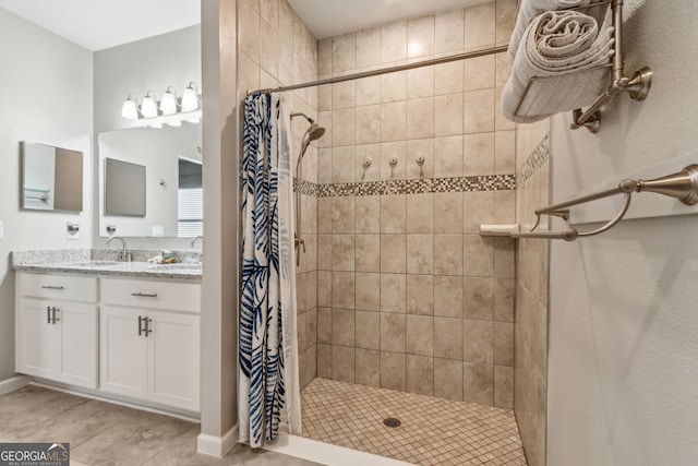 bathroom featuring baseboards, vanity, tile patterned floors, and tiled shower