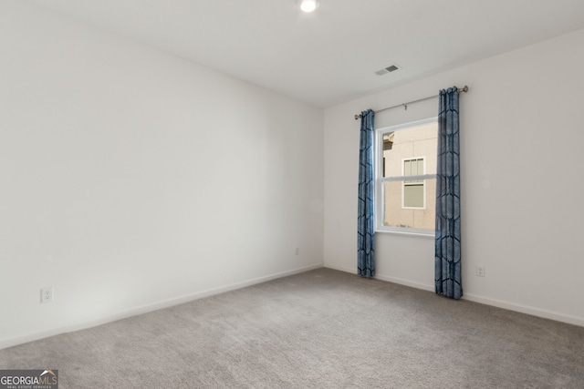 carpeted spare room with baseboards and visible vents