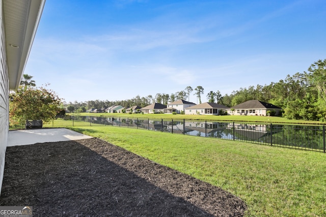 view of yard featuring a fenced backyard, a residential view, a water view, and a patio area