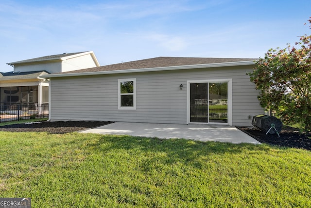 rear view of property featuring fence, a patio area, and a yard