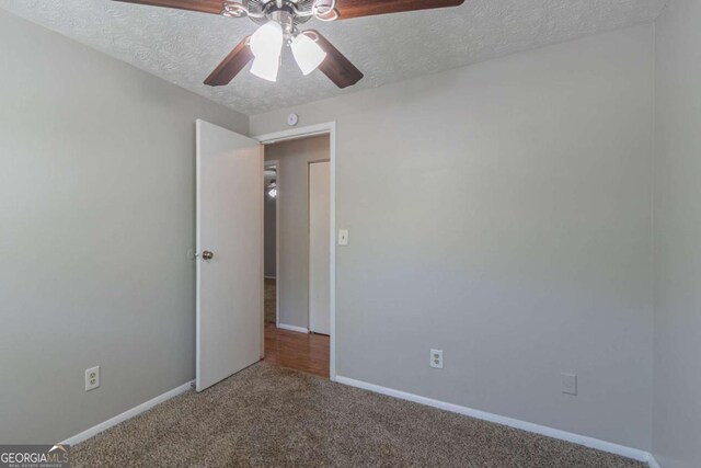2092 Countydown Ln, Stone Mountain, GA 30088 - unfurnished bedroom with ceiling fan, baseboards, carpet flooring, and a textured ceiling