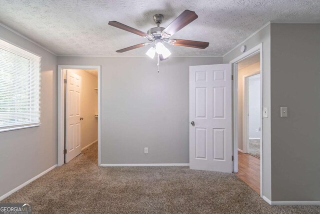 2092 Countydown Ln, Stone Mountain, GA 30088 - unfurnished bedroom with carpet flooring, a spacious closet, a textured ceiling, and ornamental molding