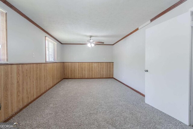 2092 Countydown Ln, Stone Mountain, GA 30088 - carpeted spare room with wainscoting, ceiling fan, crown molding, and wooden walls