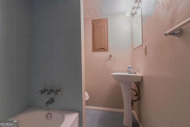 2092 Countydown Ln, Stone Mountain, GA 30088 - bathroom with electric panel, a textured ceiling, toilet, baseboards, and shower / washtub combination
