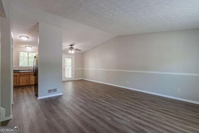 2092 Countydown Ln, Stone Mountain, GA 30088 - unfurnished living room with dark wood-type flooring, a textured ceiling, a ceiling fan, and baseboards