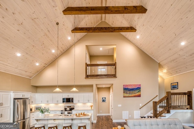1016 Twisted Oak Rd Unit 115, Talking Rock, GA 30175 - kitchen with appliances with stainless steel finishes, a wood ceiling with exposed beams, high vaulted ceiling, white cabinets, and a kitchen island with sink