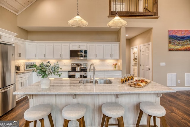 1016 Twisted Oak Rd Unit 115, Talking Rock, GA 30175 - kitchen with appliances with stainless steel finishes, high vaulted ceiling, white cabinetry, and decorative backsplash