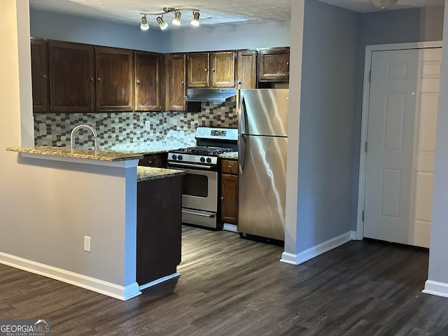 4828 Westridge Dr, Norcross, GA 30093 - kitchen featuring dark brown cabinetry, decorative backsplash, under cabinet range hood, appliances with stainless steel finishes, and baseboards