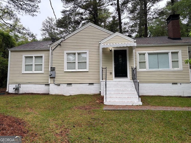 view of front of property featuring a chimney, crawl space, a front yard, and a shingled roof
