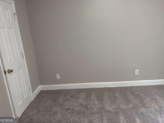 unfurnished room featuring carpet floors and baseboards