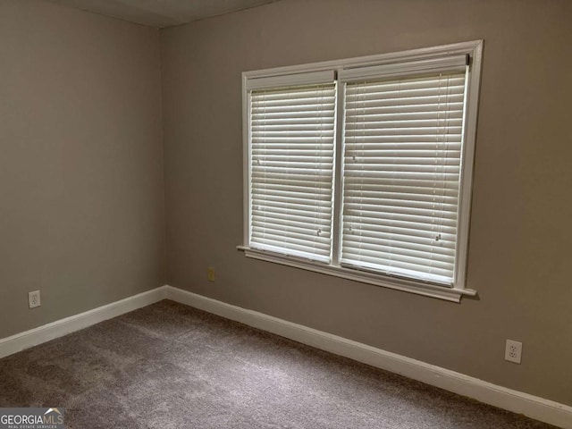 carpeted spare room with baseboards