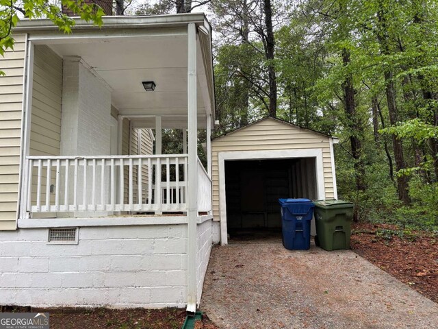 view of side of home with an outdoor structure, concrete driveway, and a garage