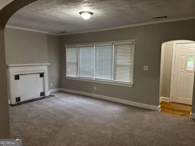 unfurnished living room featuring visible vents, carpet, baseboards, and arched walkways