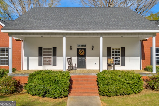 view of front of home with a shingled roof and covered porch