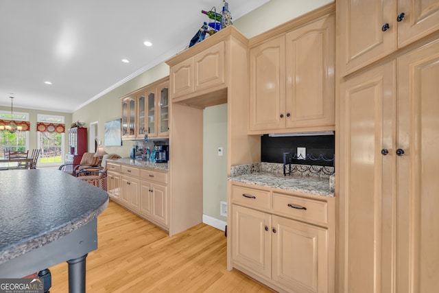 kitchen featuring light brown cabinets, glass insert cabinets, light wood-style flooring, ornamental molding, and recessed lighting