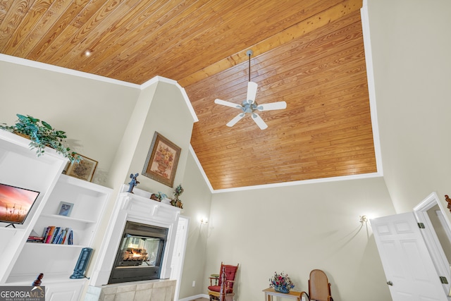 room details featuring wooden ceiling, a tile fireplace, a ceiling fan, and crown molding
