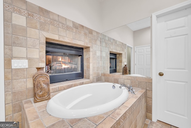 full bath featuring a bath and a glass covered fireplace