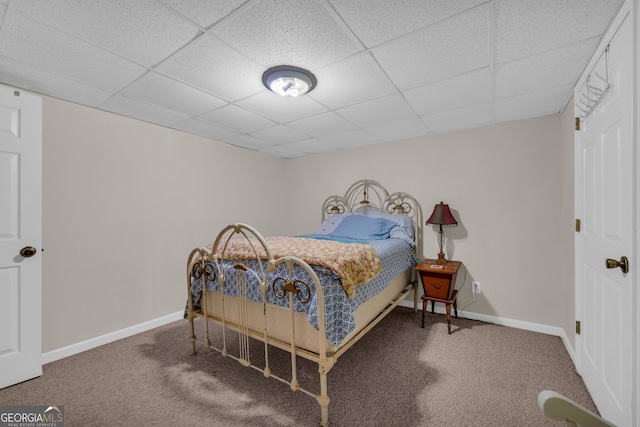 bedroom featuring a paneled ceiling, baseboards, and carpet