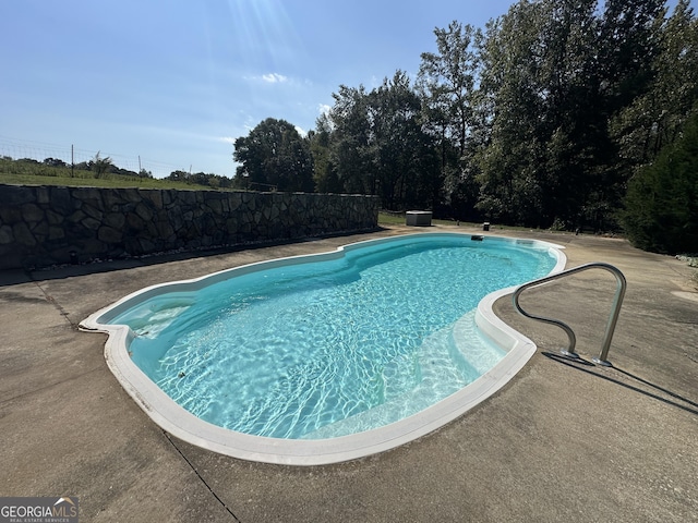 view of swimming pool featuring fence, a fenced in pool, and a patio