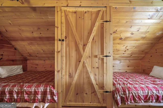 bedroom with wood ceiling, vaulted ceiling, and wood walls