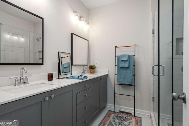 bathroom featuring a shower stall, visible vents, a sink, and double vanity