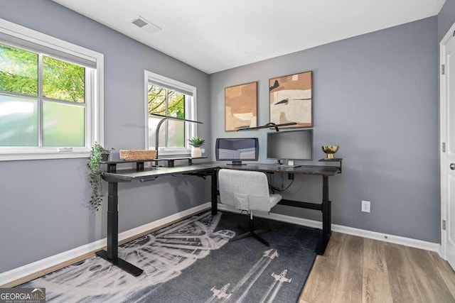 office space featuring baseboards, wood finished floors, and visible vents