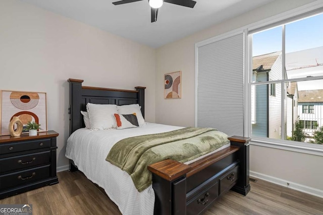 bedroom featuring ceiling fan, baseboards, and wood finished floors