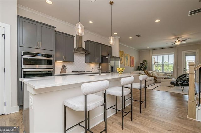 820 Fair View Cir, Roswell, GA 30076 - kitchen with stainless steel appliances, a large island, wall chimney exhaust hood, crown molding, and decorative backsplash