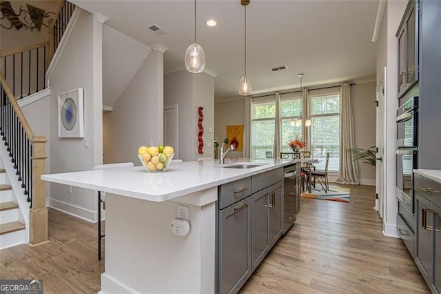 820 Fair View Cir, Roswell, GA 30076 - kitchen featuring light countertops, light wood-style floors, gray cabinets, and a sink