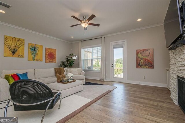 820 Fair View Cir, Roswell, GA 30076 - living room featuring a stone fireplace, visible vents, wood finished floors, crown molding, and ceiling fan