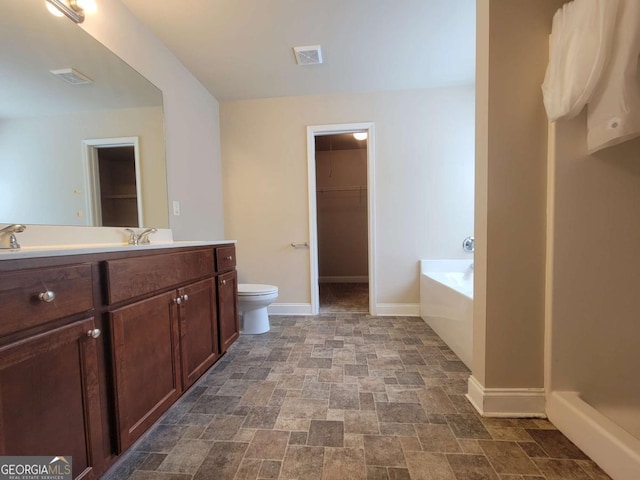 115 Heather Ln, Commerce, GA 30529 - full bath with a walk in closet, baseboards, toilet, stone finish floor, and visible vents