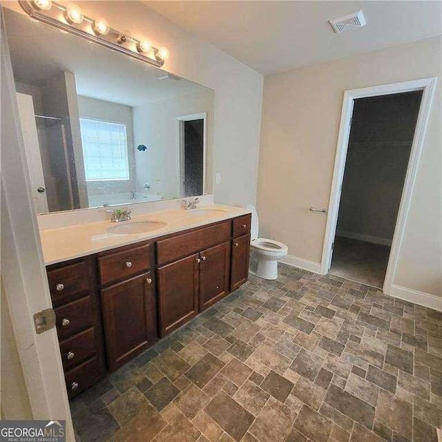 115 Heather Ln, Commerce, GA 30529 - bathroom with baseboards, a sink, double vanity, and toilet