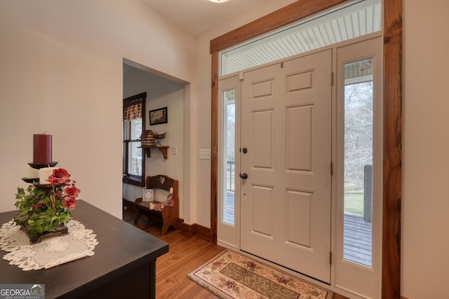 foyer entrance with light wood-style flooring and baseboards