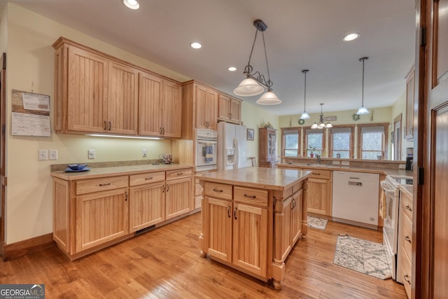 kitchen featuring light brown cabinets, light countertops, white appliances, and light wood-style floors