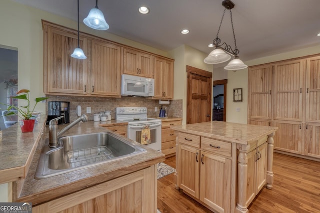 kitchen with decorative backsplash, white appliances, a sink, and light brown cabinetry