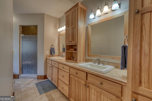 bathroom featuring double vanity, a shower stall, tile patterned flooring, and a sink