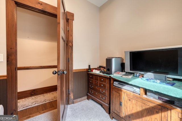 home office with light carpet and a wainscoted wall